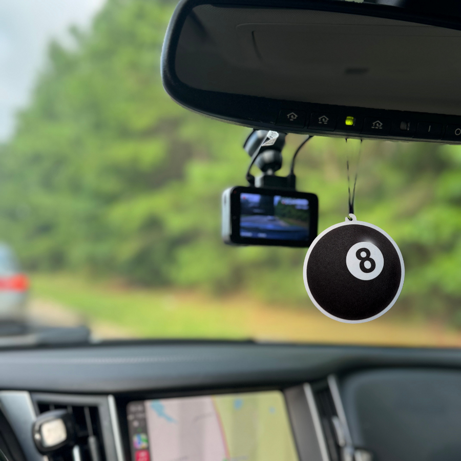 8ball air freshener hanging of the rearview mirror on the inside of a car